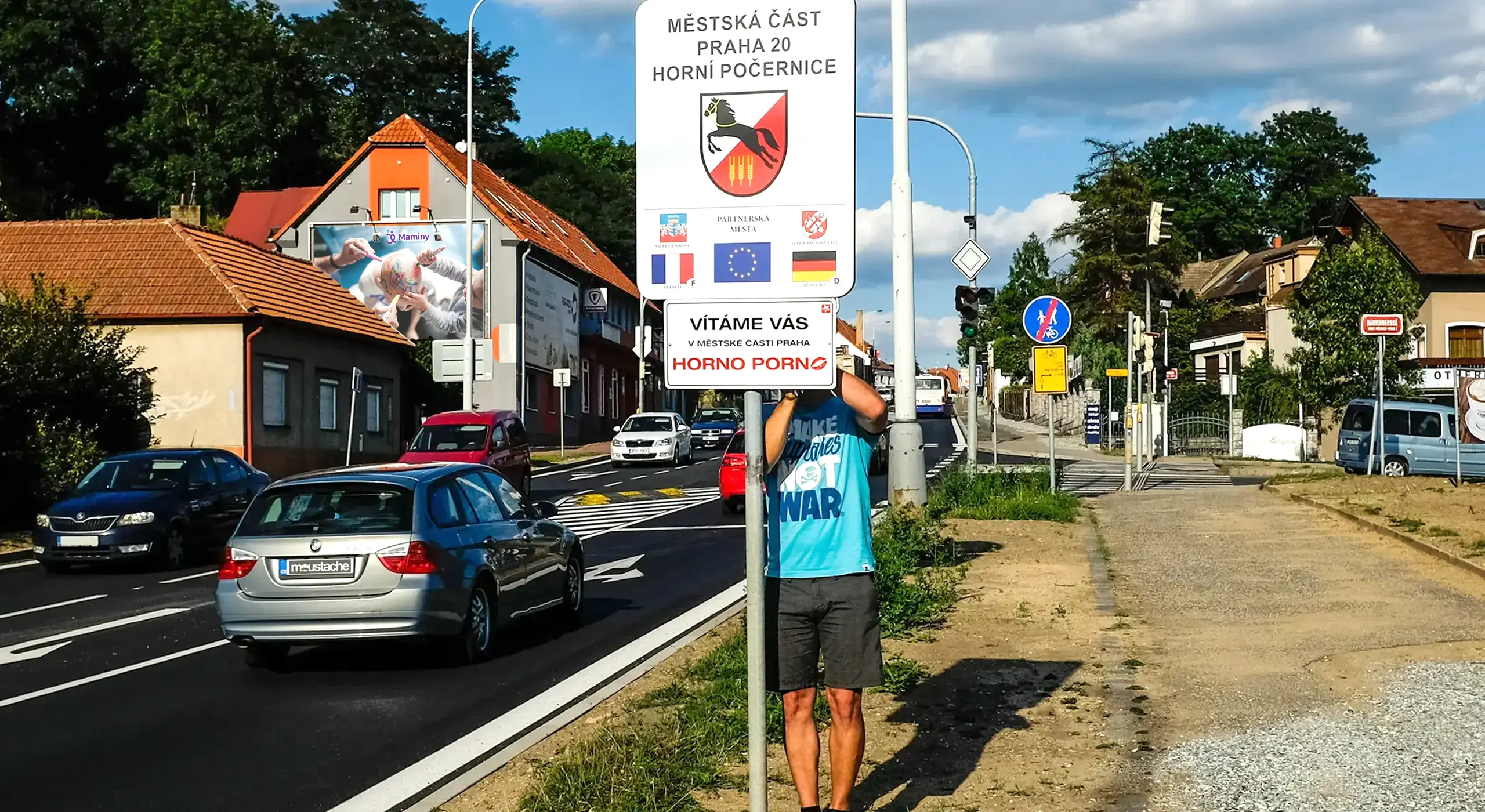 Vjezd do Horních Počernic (ul. Náchodská, směr od Černého Mostu) – streetartový umělec moustache instaluje smaltovanou ceduli "Vítáme vás v městské části HornoPorno".